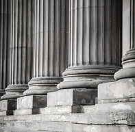 bottom portion of Greek or Roman pillars, symbolizing the strength and value add of advice given with different fee options